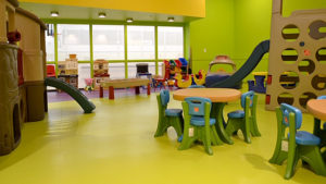Resilient sheet vinyl flooring in a lime green color in an indoor children play room.