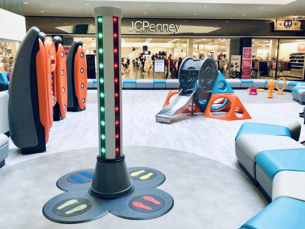 Two colored Safe Landings Resilient Sheet Vinyl System installed in shopping mall play area with multiple play structures.