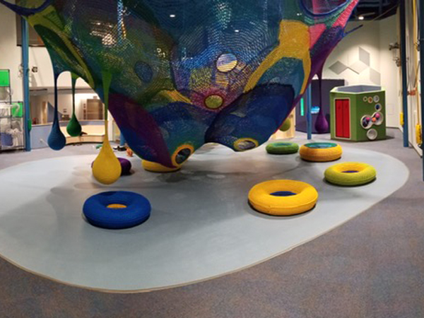 Safe kids flooring installed in a museum play room with unique knitted hanging balls.