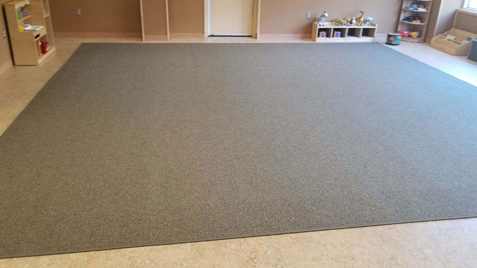 Impact absorbing rug for child care centers with ADA edges.