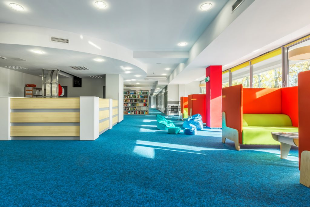 Impact absorbing blue carpeting inside a library story time area.